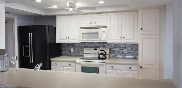 a kitchen with stainless steel appliances white cabinets and a refrigerator