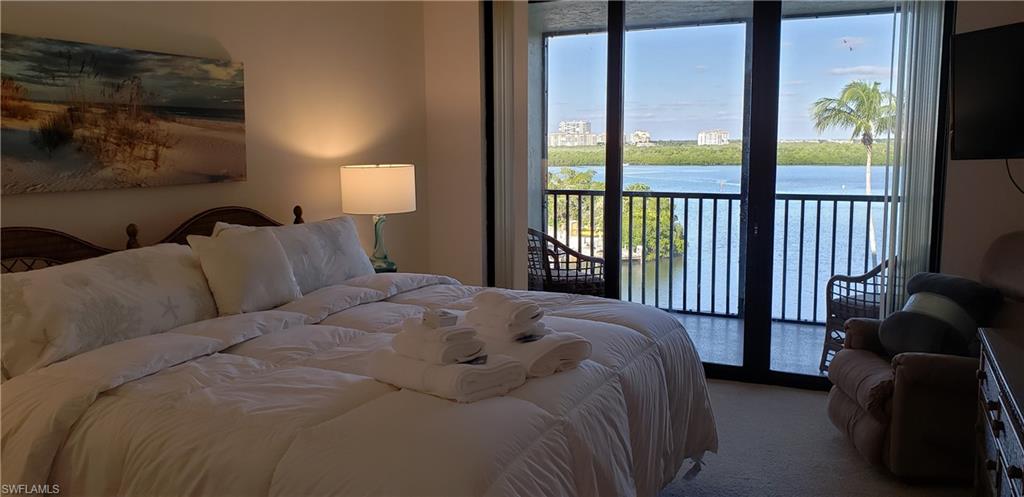 15 Bluebill Avenue, Unit 406 Naples, FL 34108 - Photo 9 of 18 a bed sitting in a bedroom next to a window