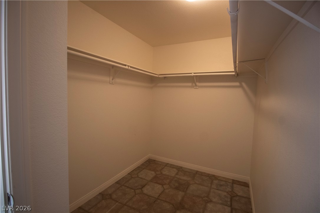119 West Victory Road Henderson, NV 89015 - Photo 14 of 26 A well-organized walk-in closet with ample storage solutions and patterned tile flooring.