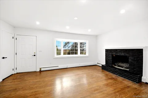 a view of an empty room with fire place and a window