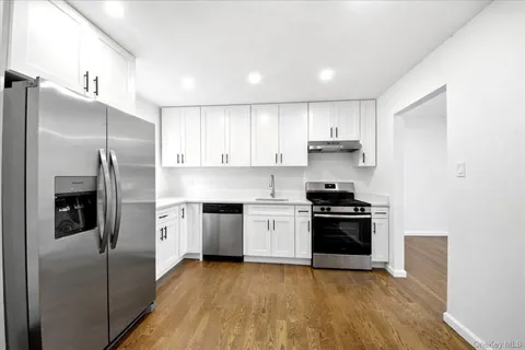 a kitchen with stainless steel appliances granite countertop a stove a refrigerator and a sink