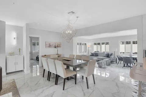 a view of a dining room with furniture and chandelier