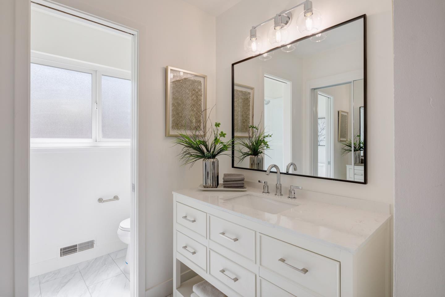 1650 Manitoba Drive Sunnyvale, CA 94087 - Photo 16 of 26 a bathroom with a granite countertop sink a mirror and a shower