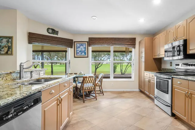 a kitchen with stainless steel appliances granite countertop a stove a sink and a refrigerator