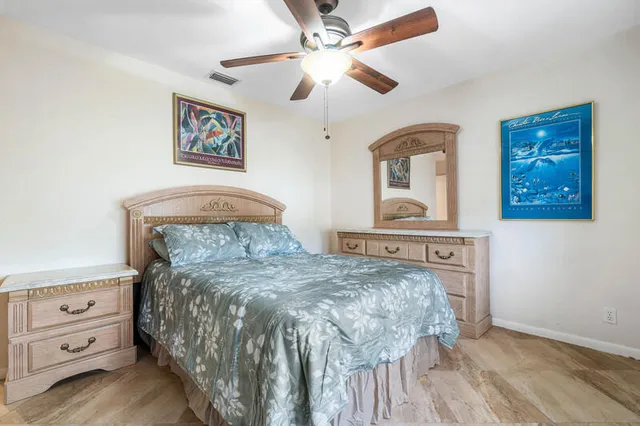 a bedroom with a bed and a lamp on dresser