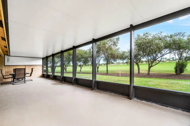 a view of an empty room with floor to ceiling windows and a table