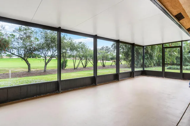 a view of an empty room with large windows with view of lake