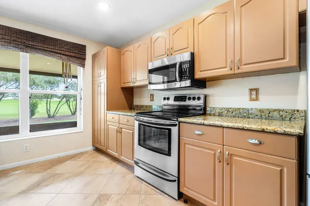 a kitchen with stainless steel appliances granite countertop a stove sink and cabinets