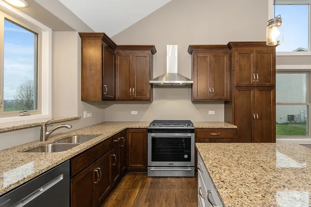 a kitchen with stainless steel appliances granite countertop a sink stove and refrigerator
