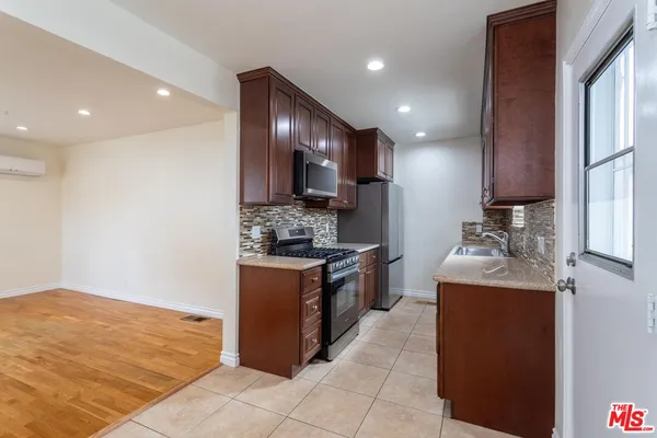 a kitchen with stainless steel appliances granite countertop a refrigerator and a stove