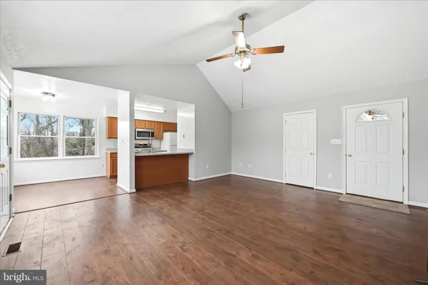 a view of an empty room with a window and wooden floor