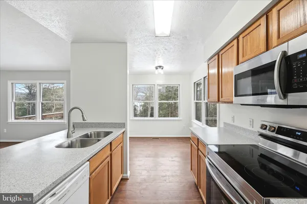 a kitchen with stainless steel appliances granite countertop a sink and a microwave