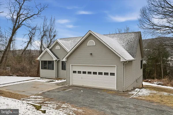 a view of a house with a big yard and large trees