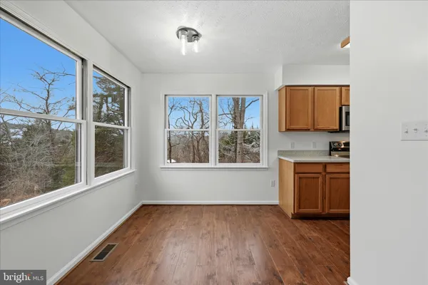 an empty room with a window and wooden floor