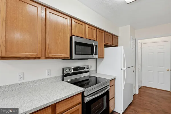 a kitchen with stainless steel appliances a microwave a stove and cabinets