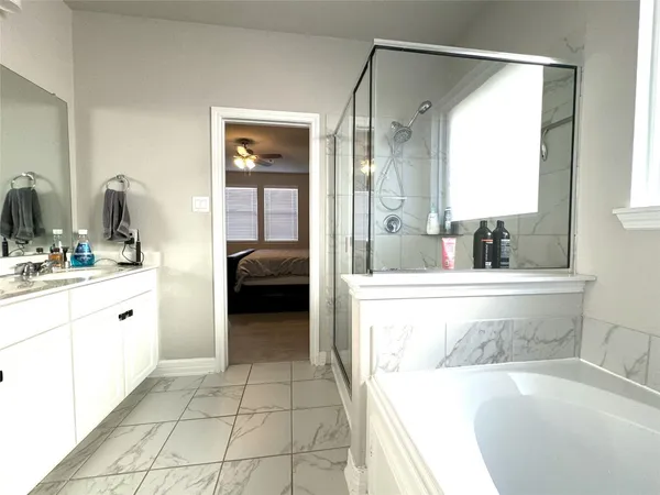 a en suite bathroom with a tub sink and mirror
