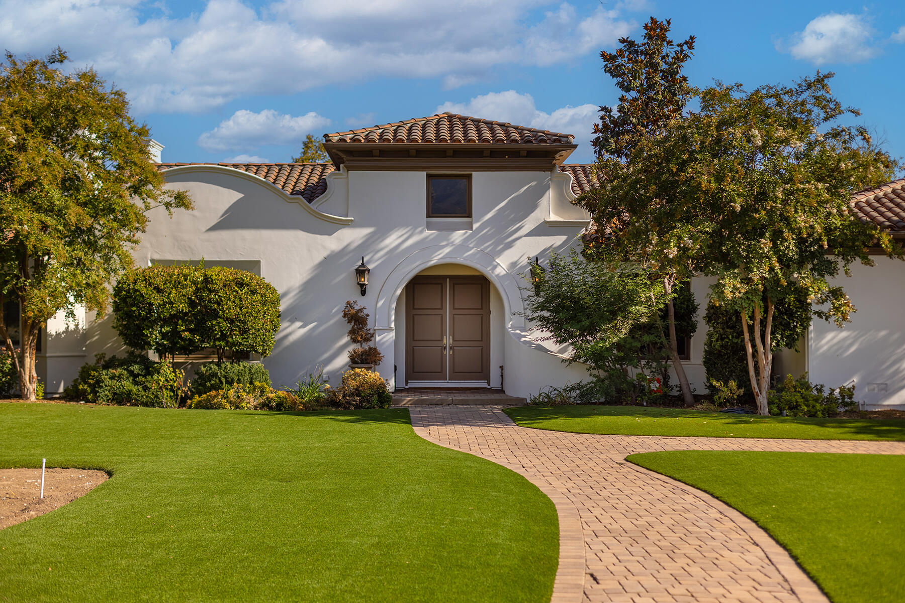 a front view of a house with yard and green space