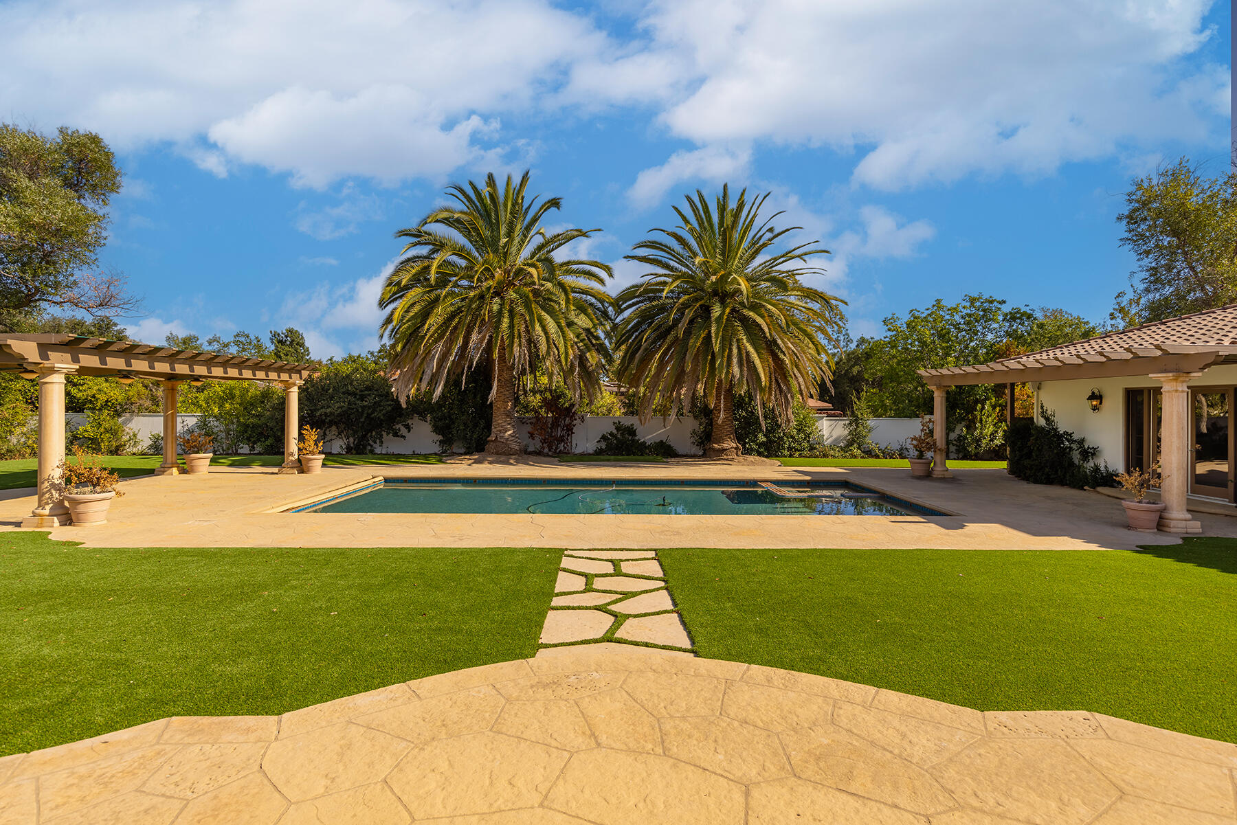1000 Shokat Drive Ojai, CA 93023 - Photo 26 of 55 a view of a swimming pool with a lawn chairs under palm trees