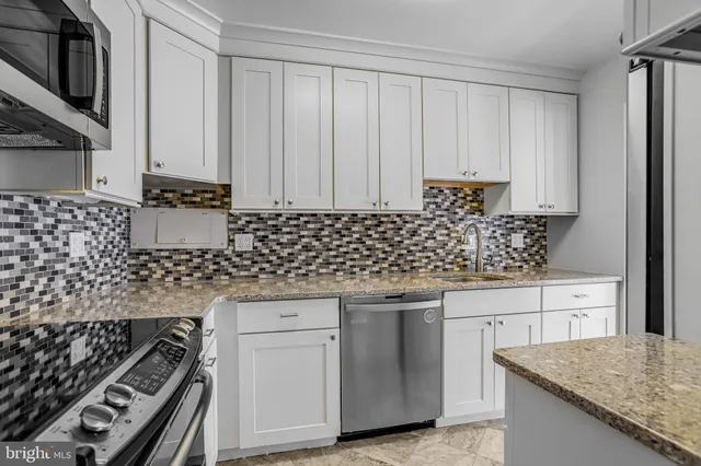 a kitchen with granite countertop a sink stove and cabinets
