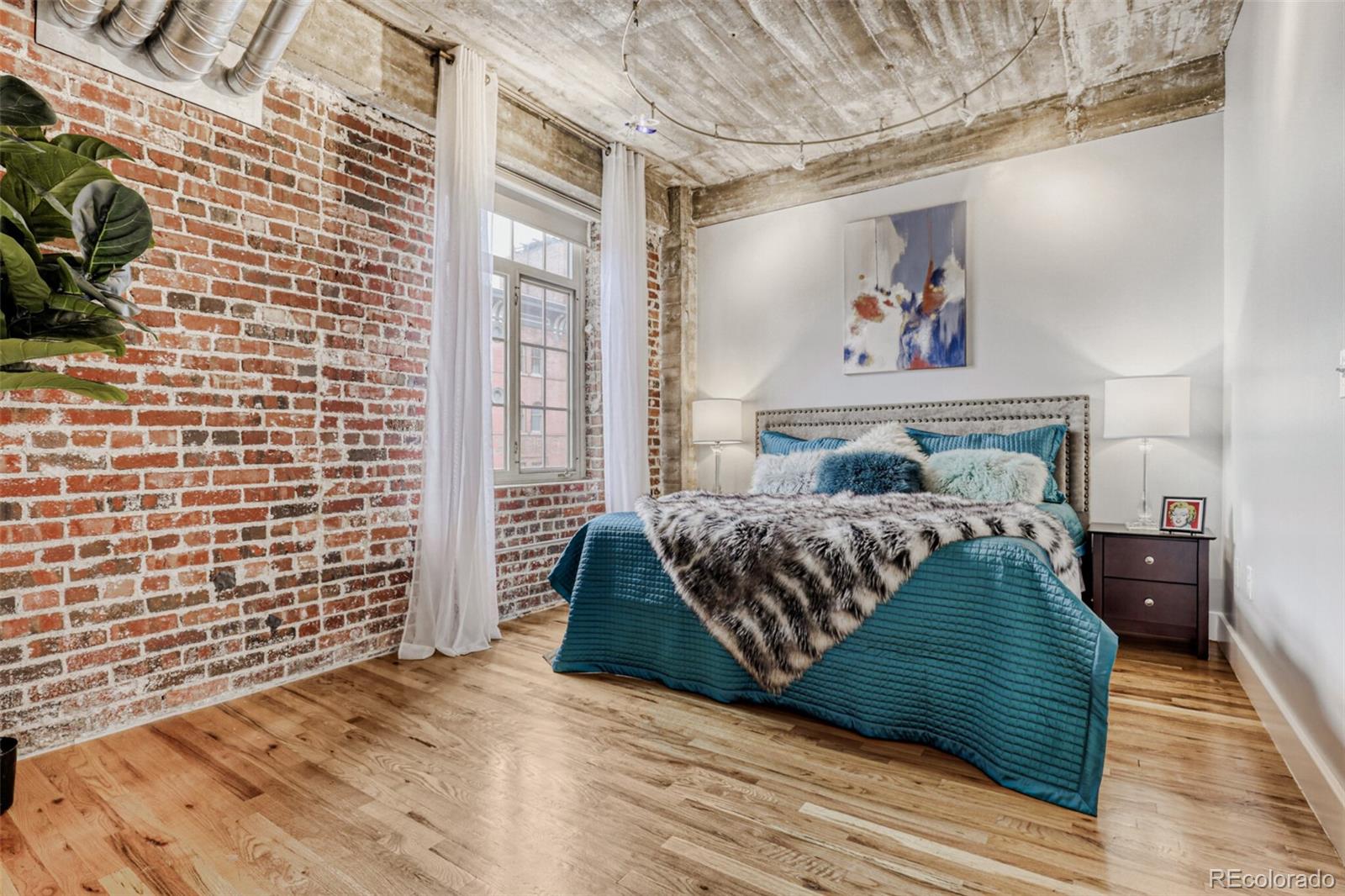 1449 Wynkoop Street, Unit 506 Denver, CO 80202 - Photo 14 of 39 a bedroom with a bed and a painting on the wall