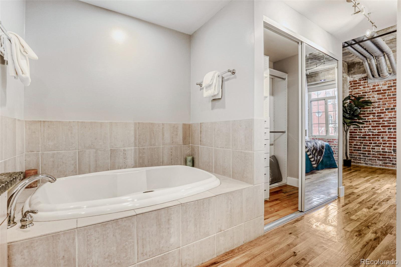 1449 Wynkoop Street, Unit 506 Denver, CO 80202 - Photo 16 of 39 a white bath tub sitting in a bathroom