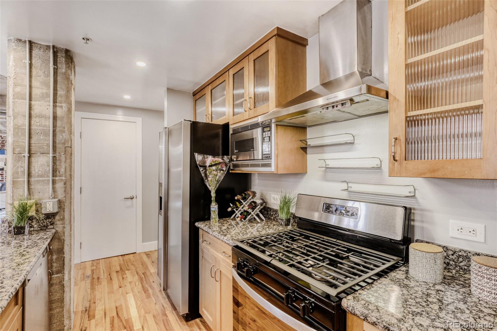 1449 Wynkoop Street, Unit 506 Denver, CO 80202 - Photo 5 of 39 a kitchen with stainless steel appliances granite countertop a stove and a refrigerator