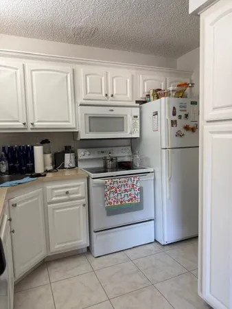 a kitchen with refrigerator and cabinets