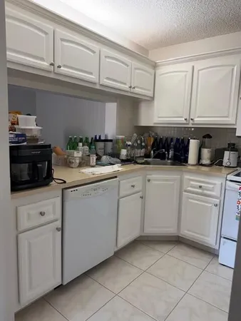 a kitchen with white cabinets and white appliances
