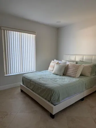 a bed sitting in a bedroom next to a window