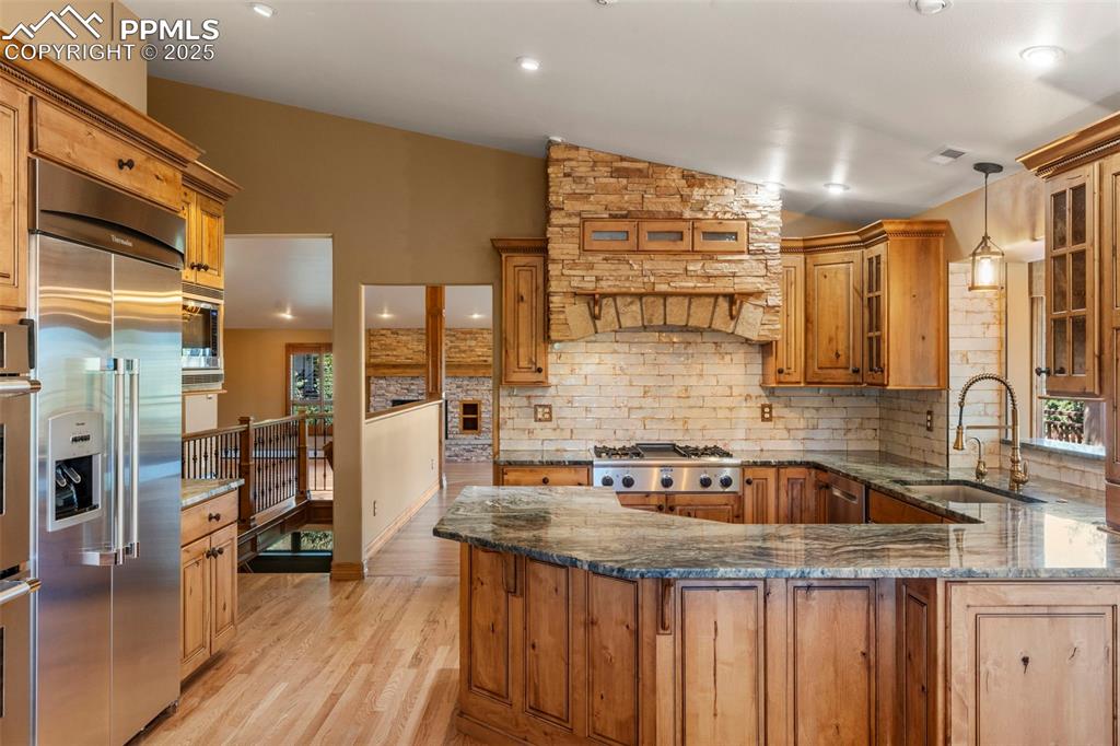 40 Upland Road Colorado Springs, CO 80906 - Photo 12 of 46 a kitchen with stainless steel appliances granite countertop a sink and wooden cabinets