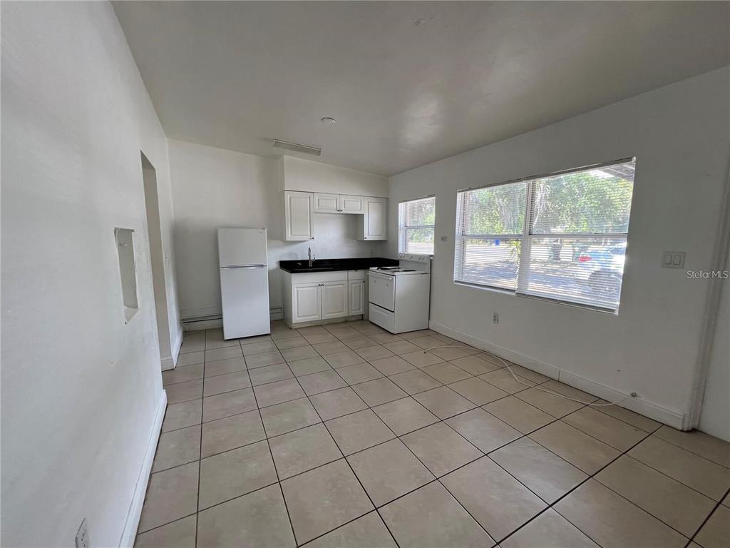 989 South Fiske Boulevard Rockledge, FL 32955 - Photo 4 of 14 a large white kitchen with a sink a refrigerator and window