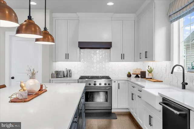 a kitchen with stainless steel appliances granite countertop a sink a stove a refrigerator and island with wooden floor