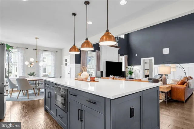 a kitchen with stainless steel appliances kitchen island a white cabinets and wooden floor
