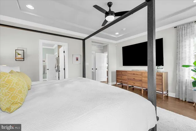 a bedroom with a bed mirror and a potted plant