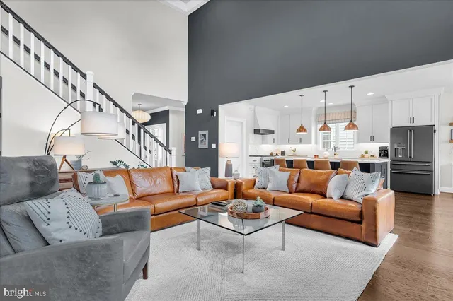 a living room with furniture stairs and a wooden floor