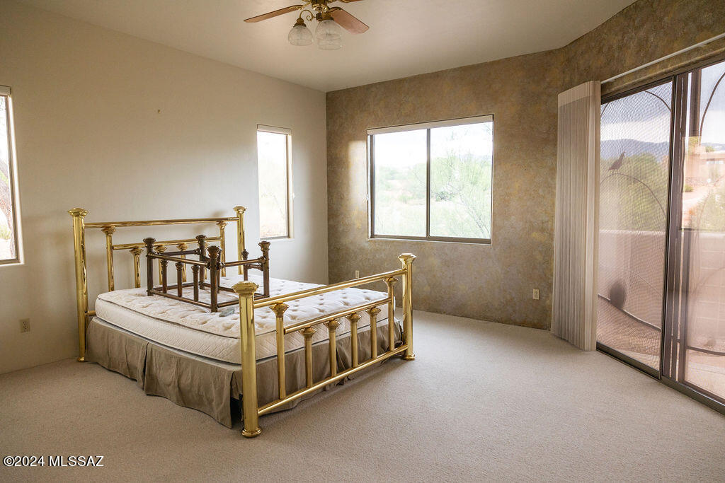 771 West Sedona Ridge Place Oro Valley, AZ 85755 - Photo 6 of 22 a bedroom with a bed a chandelier and windows