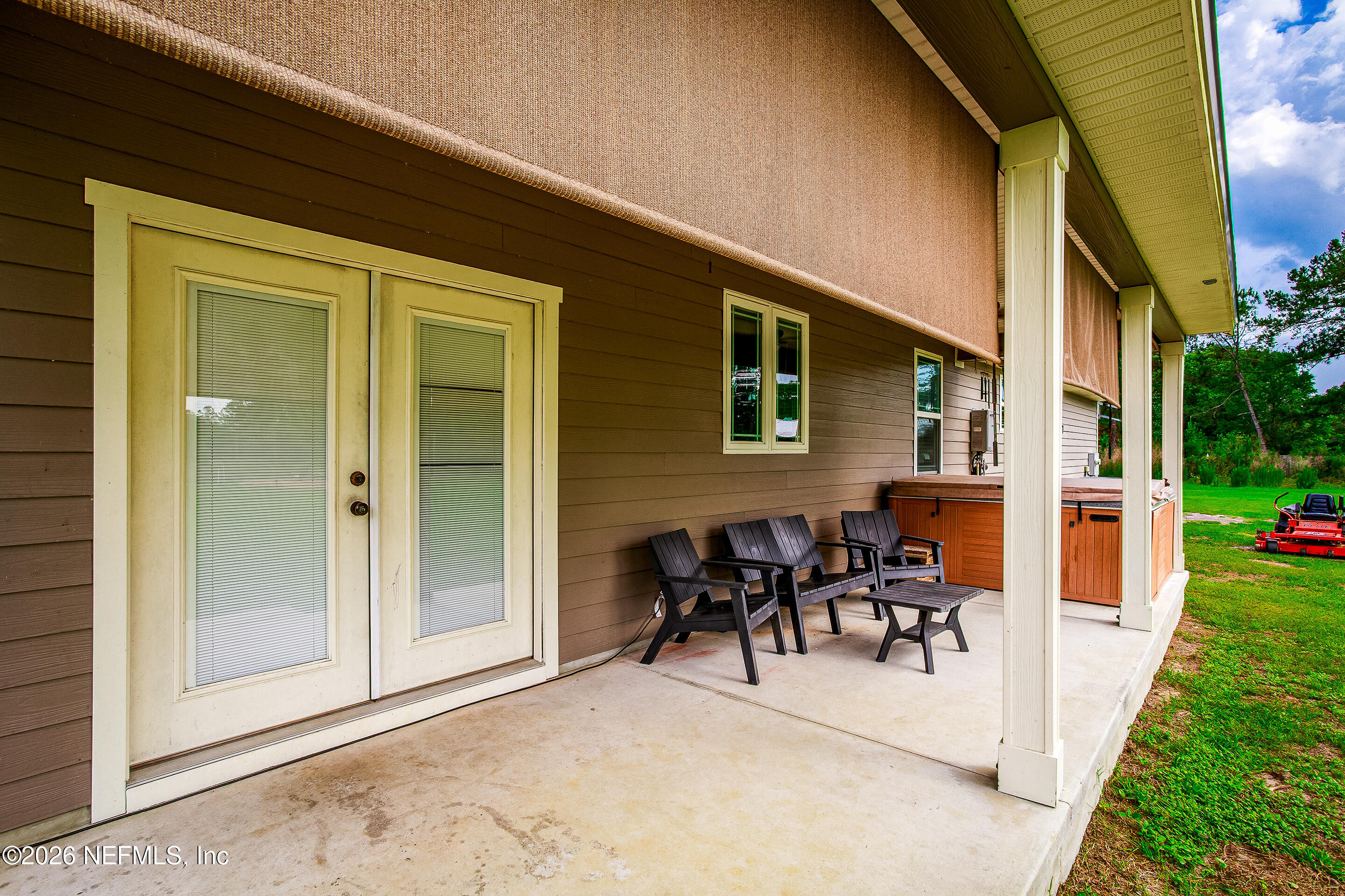 26575 Sheared Stokes Road Hilliard, FL 32046 - Photo 20 of 39 a view of a patio with table and chairs and garden