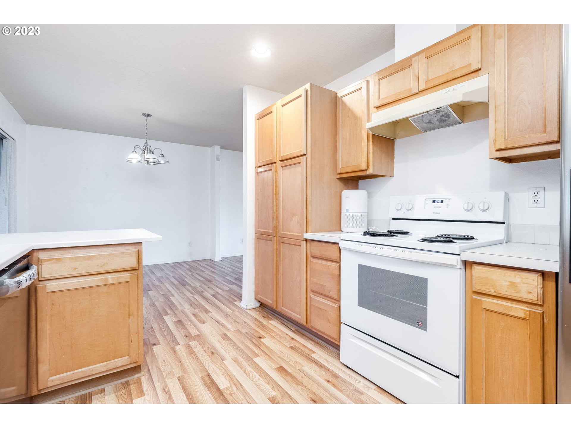 713 Northeast Mariners Loop Portland, OR 97211 - Photo 17 of 40 a kitchen with stainless steel appliances white cabinets and wooden floor