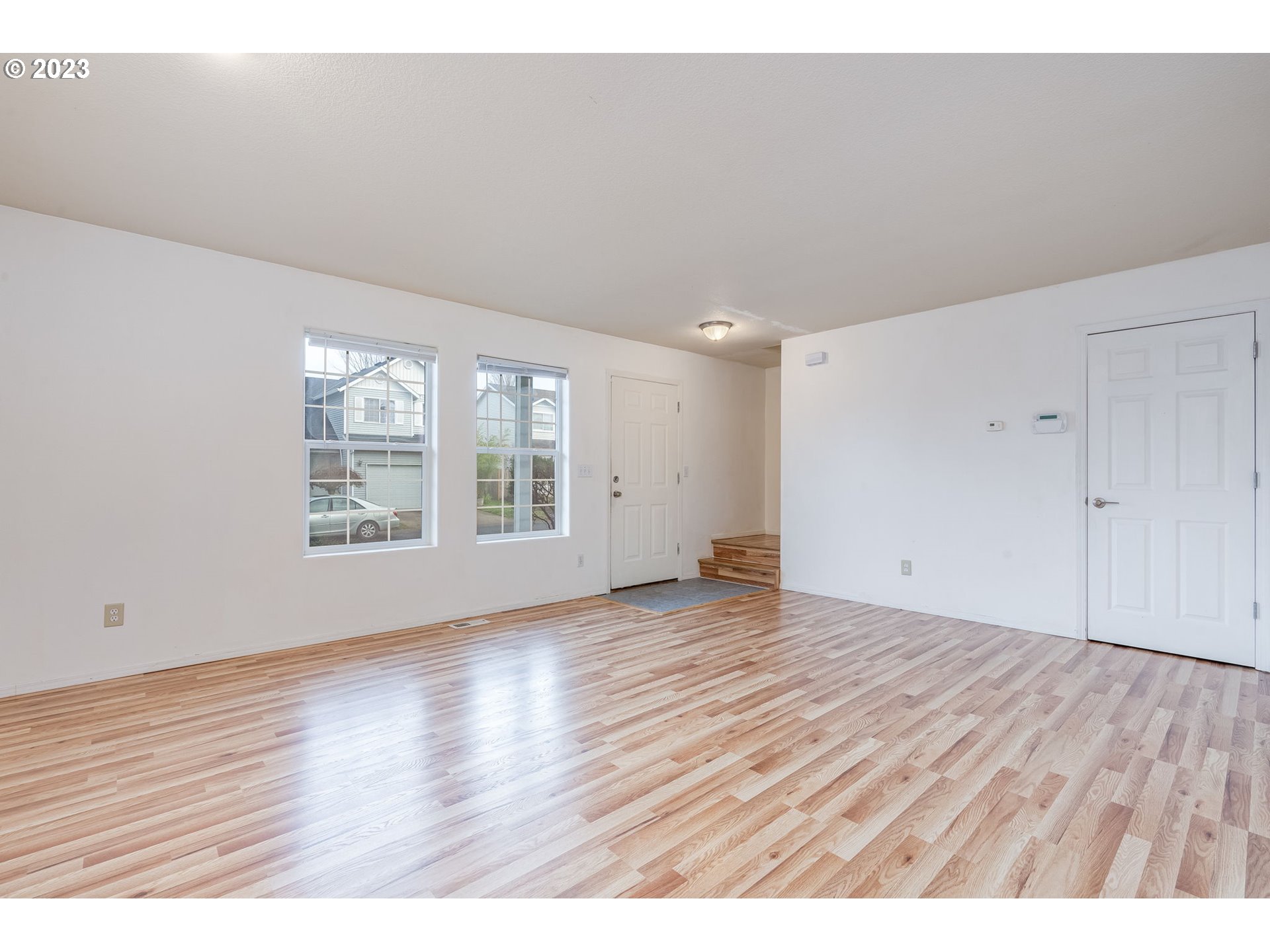 713 Northeast Mariners Loop Portland, OR 97211 - Photo 6 of 40 an empty room with wooden floor and windows