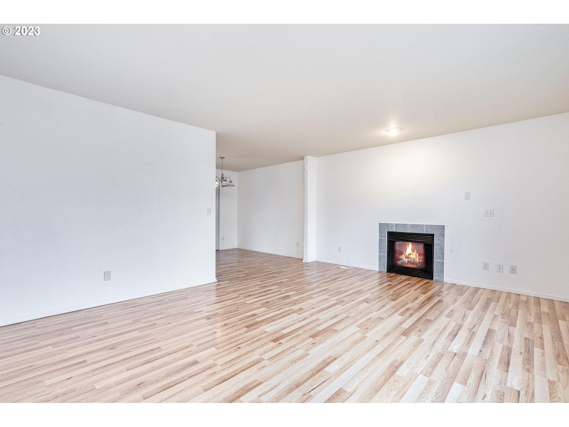 713 Northeast Mariners Loop Portland, OR 97211 - Photo 8 of 40 a view of an empty room with wooden floor and a window