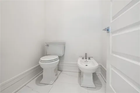 a bathroom with a toilet sink vanity and mirror