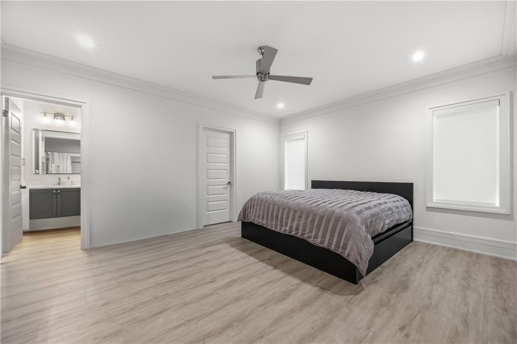 1105 Moores Mill Road Northwest Atlanta, GA 30327 - Photo 62 of 77 a bedroom with a large bed and wooden floor