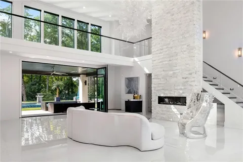 a living room with fireplace furniture and a large window