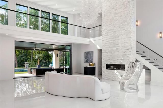 a living room with fireplace furniture and a large window