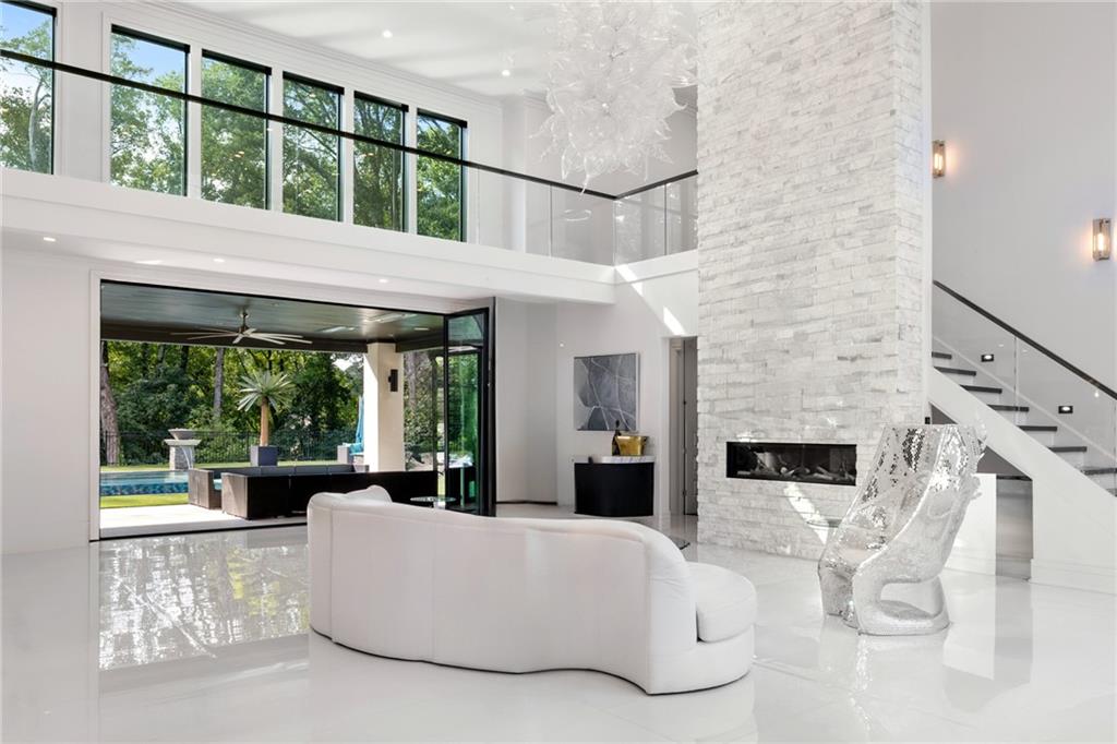 1105 Moores Mill Road Northwest Atlanta, GA 30327 - Photo 8 of 77 a living room with furniture large windows a flat tv screen and a table