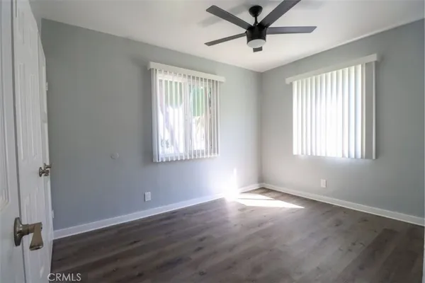 a view of empty room with wooden floor and window