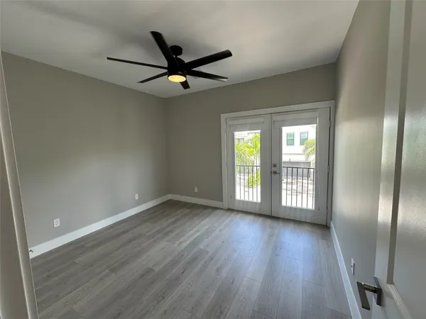 an empty room with wooden floor a ceiling fan and closet area