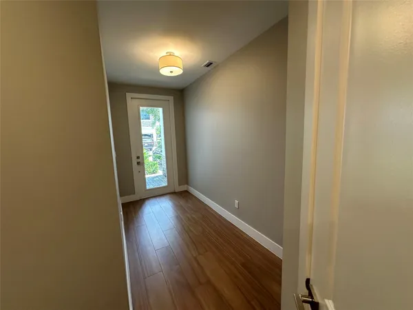 a view of a hallway with wooden floor and closet area