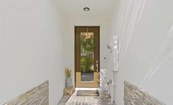 a view of a hallway with wooden floor and a bathroom