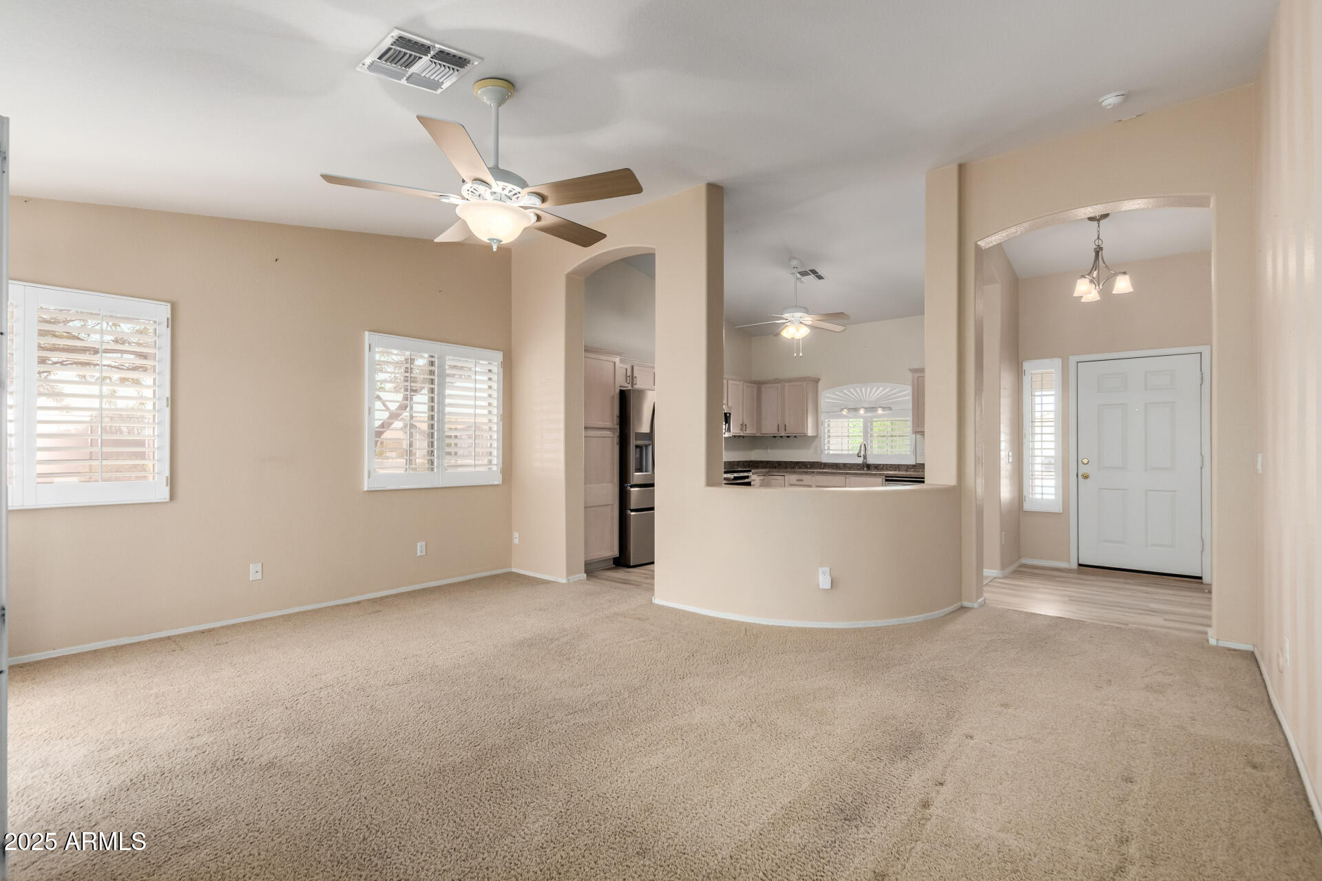 2101 South Meridian Road, Unit 301 Apache Junction, AZ 85120 - Photo 4 of 30 a view of a kitchen with a kitchen island wooden floor and a ceiling fan